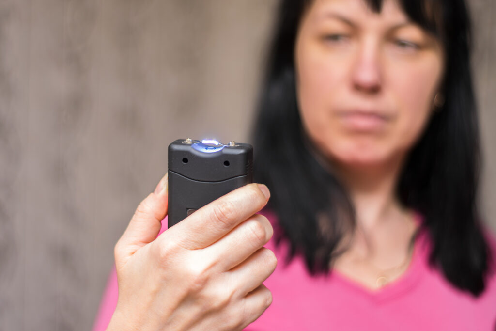 What You Need To Know When Buying A Stun Gun article image showing a woman holding a stun gun. 